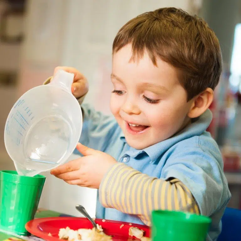 boy pouring water into a cup