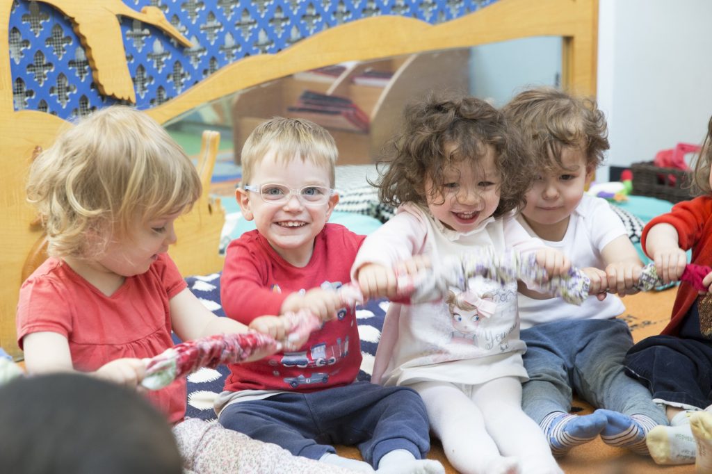 children holding onto rope