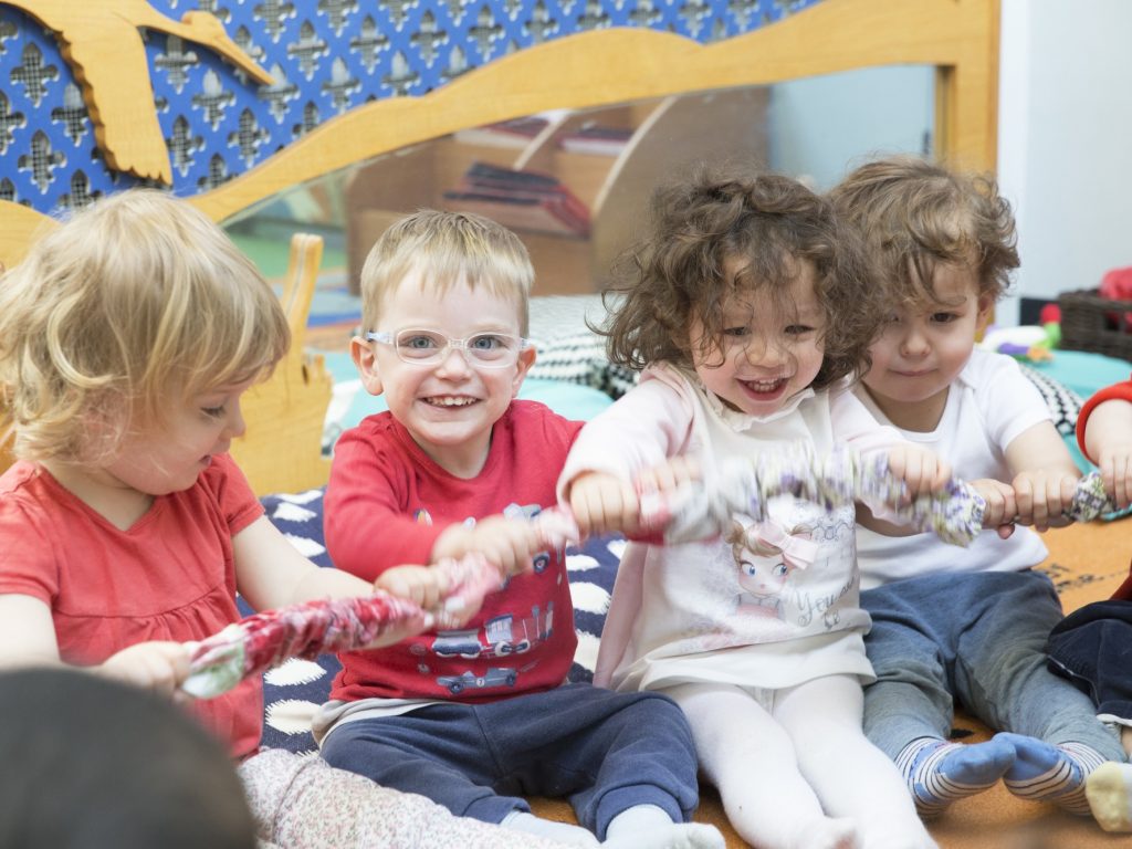 children holding onto rope