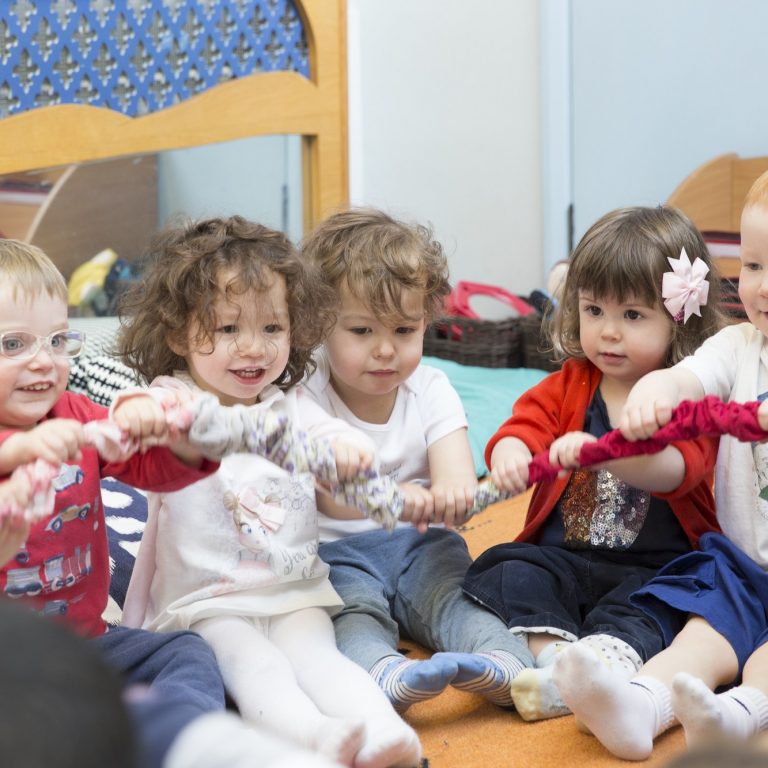 children holding onto rope