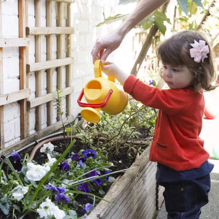 child watering flowers