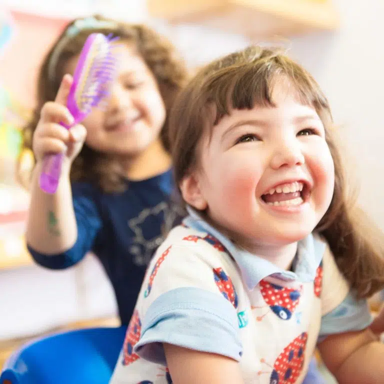 girl smiling as her hair is brushed