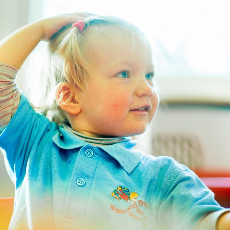 child with a hand on her head