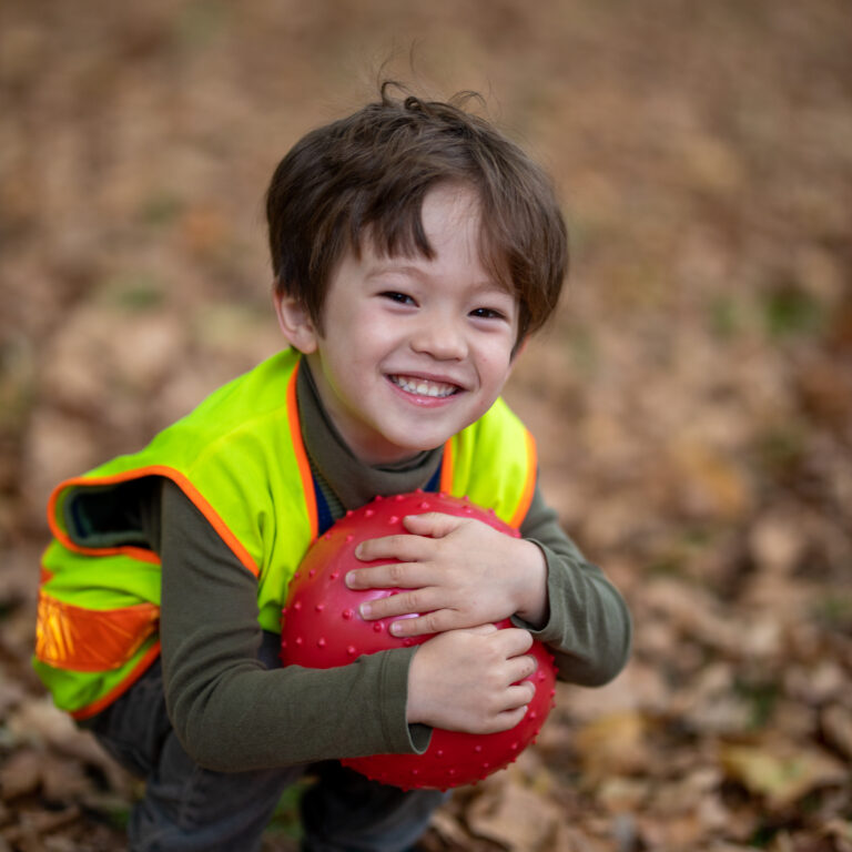 child holding a red ball
