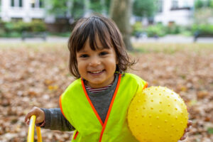 child holding a yellow ball